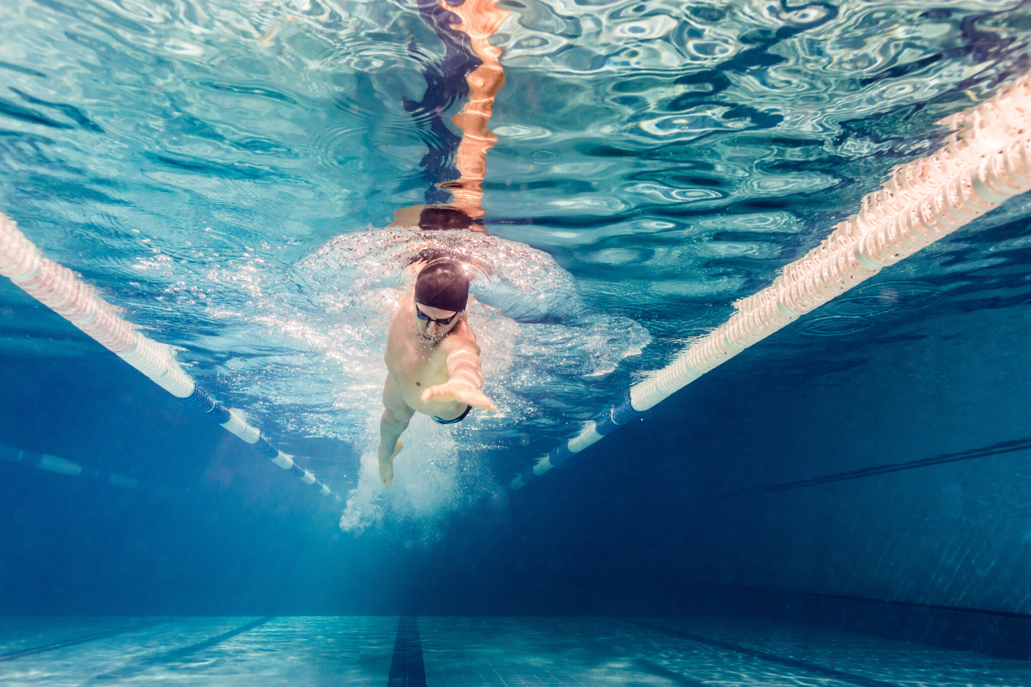 A swimmer with an outstretched arm working on flexibility, a benefit of swimming.